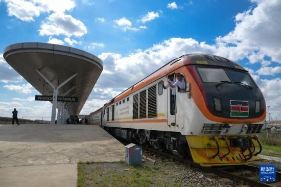 5月31日，在蒙內(nèi)鐵路內(nèi)羅畢站，機車駕駛員蔣立平（右）和博爾在即將開往蒙巴薩的E2次列車上揮手致意。新華社記者 楊光 攝