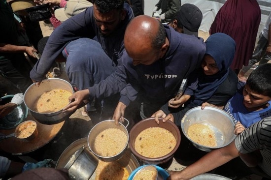 5月28日，人們?cè)诩由吵俏鞑康纳程犭y民營領(lǐng)取救助食物。新華社發(fā)（里澤克·阿卜杜勒賈瓦德攝）