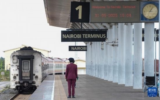 5月31日，在蒙內(nèi)鐵路內(nèi)羅畢站，工作人員目送開往蒙巴薩的E2次列車駛離站臺。新華社記者 李亞輝 攝