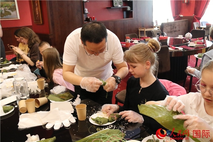 烏克蘭兒童學(xué)習(xí)體驗包粽子。人民網(wǎng)記者蔡子暢攝
