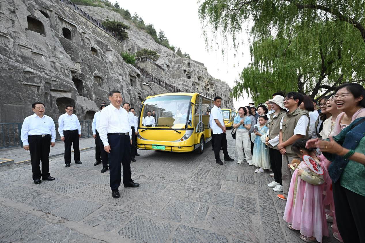 5月19日，習近平在洛陽龍門石窟考察時，同游客親切交流。