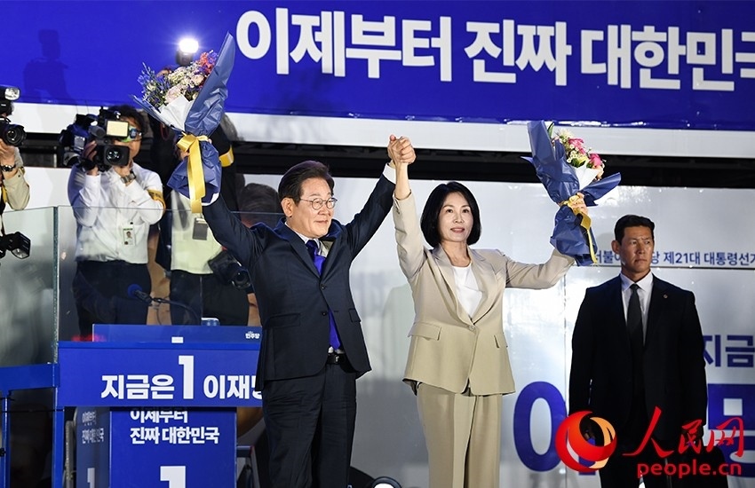 6月4日凌晨，確定當(dāng)選韓國(guó)總統(tǒng)的李在明舉手向歡呼的支持者們致意。 人民網(wǎng) 康炯彬攝